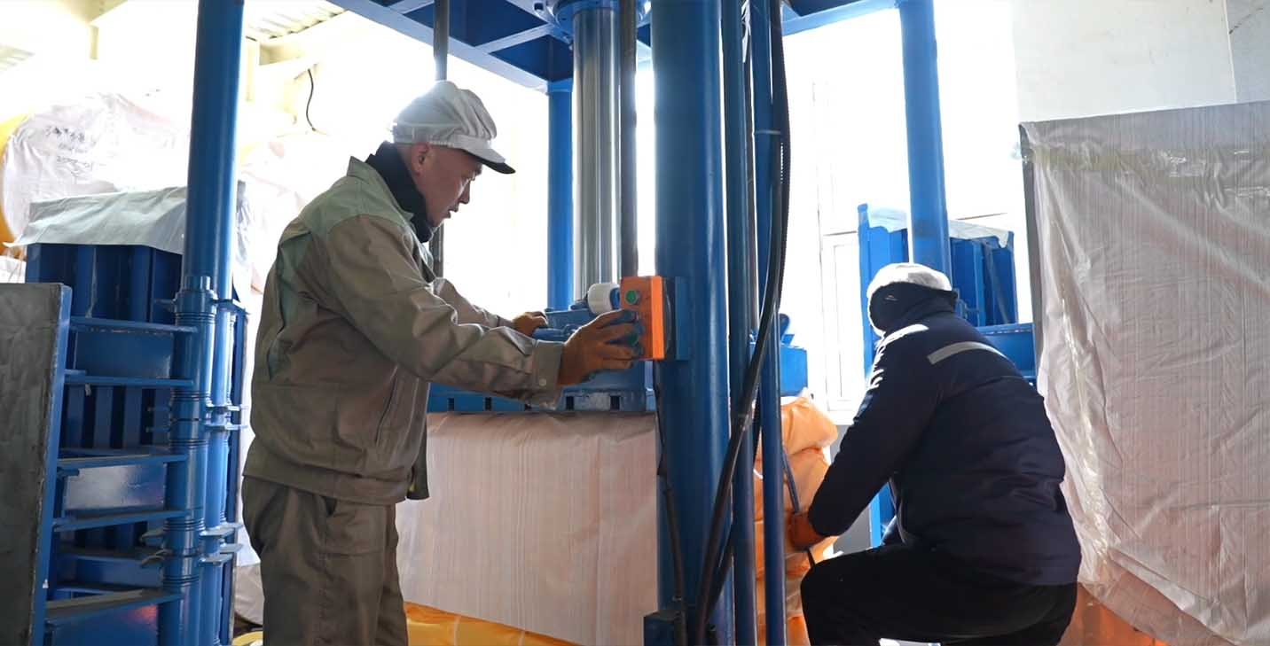 Worker inspecting packed PP woven bags before shipment