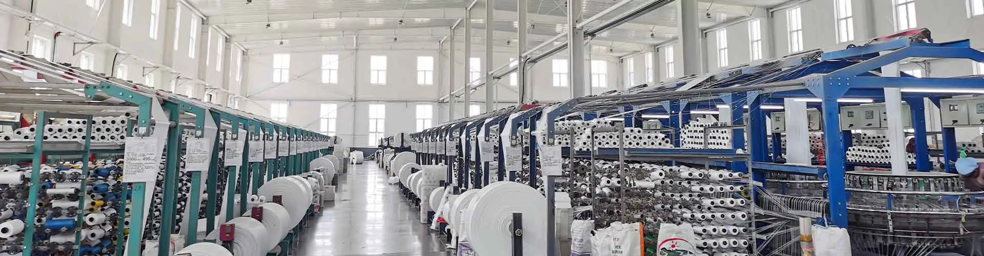 Modern circular weaving workshop producing PP woven fabric rolls